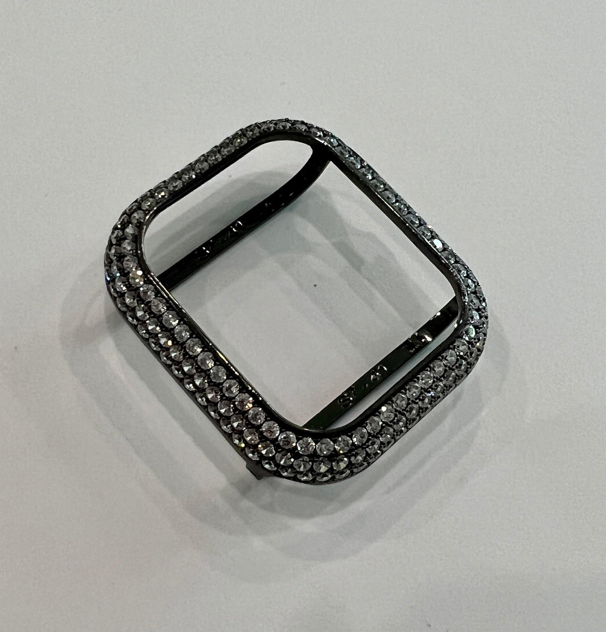 A black watch case with a diamond-encrusted design.
